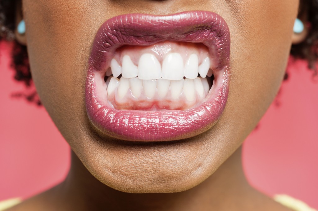 Cropped image of woman clenching teeth