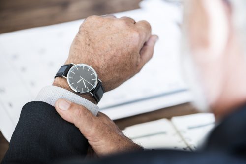 man checking his watch which states that it is 9.36