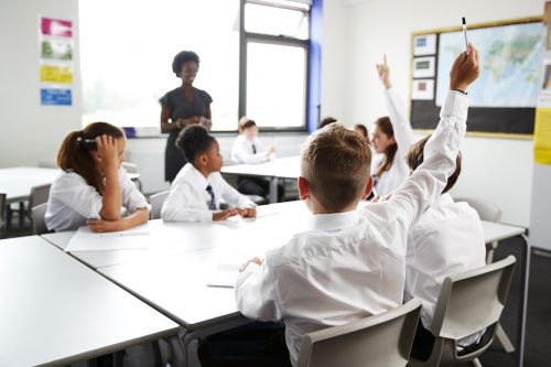 British students putting their hands up in the classroom