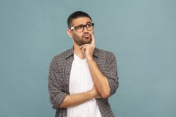 a man with glasses posing as if he is thinking